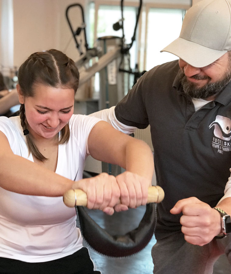 Physiotherapeut leitet eine Patientin beim Gerätetraining an – Therapie- & Trainingspunkt Bucelski Schwabach